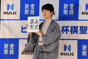 記者会見時に藤井聡太棋聖が「永世棋聖」の色紙を持っている写真